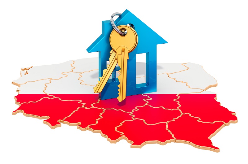 Obrys granic Polski, wypełniony kolorami białym i czerwonym, na nim leżą klucze przypięte do wielkiego breloczka w kształcie domu