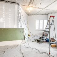 Wnętrze mieszkania w trakcie remontu lub prac wykończeniowych - ściany obłożone folia, drabina, skrzynki z narzędziami